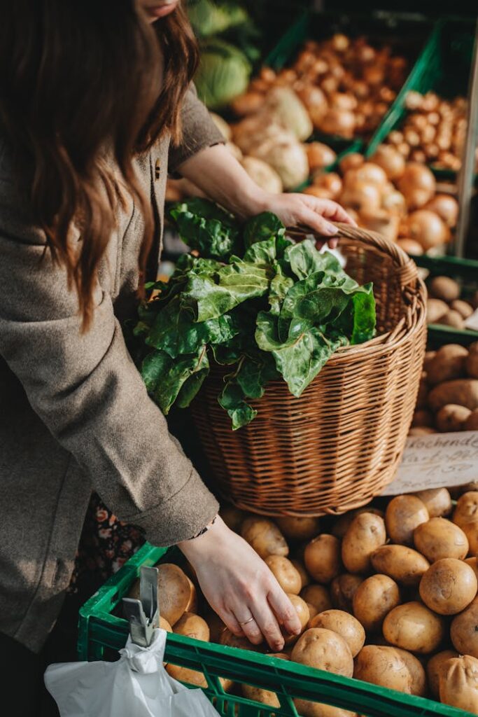A woman selecting fresh produce at an outdoor market in Erfurt, Germany.
